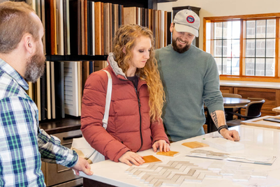 Homeowners and residential designer reviewing custom home plans and a 3D rendering