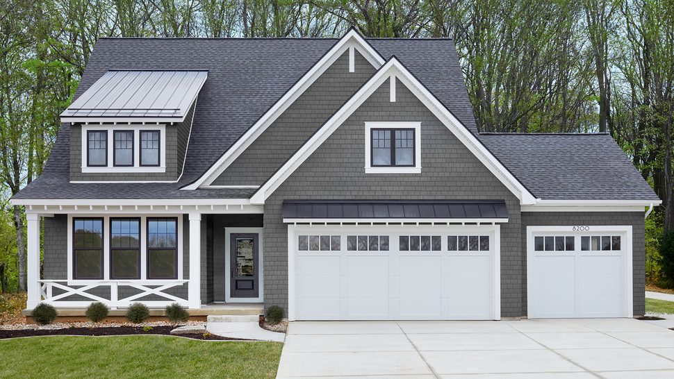 Home exterior with white window trim, porch columns and gray siding